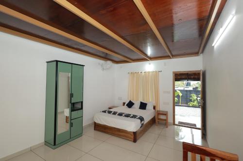 a bedroom with a bed and a window at Sarovaram residency in Munroe Island