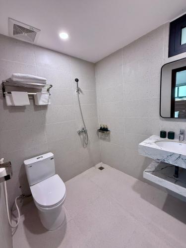 a white bathroom with a toilet and a sink at Aurora Đồng Văn Boutique Hotel in Dồng Văn