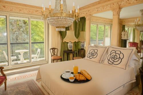 a bedroom with a bed with a tray of food on it at 21a Maréchal FOCH Avenue Paris CHAMPS-ELYSÉES in Paris