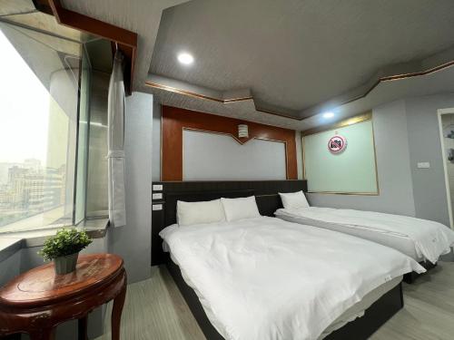 Postel nebo postele na pokoji v ubytování Love River Inn 愛河日央