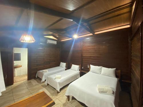 a room with two beds and a couch and a mirror at Camping e Pousada Maloca e Rodas in Alter do Chao