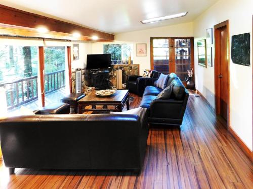 sala de estar con sofás de cuero y TV en -Fall SALE Upscale GetAway at BEACH,KAYAKS,SPA,Sauna, en Forestville