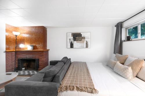 un soggiorno con divano e camino di Cozy Basement 1 BR Suite King & Queen Beds, Sleeps 6, Street Parking a Burnaby