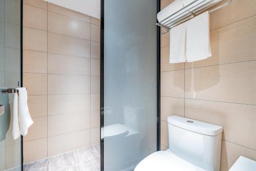 a bathroom with a toilet and a shower at Hanting Hotel Beijing Jiujingzhuang Heyi Subway Station in Beijing