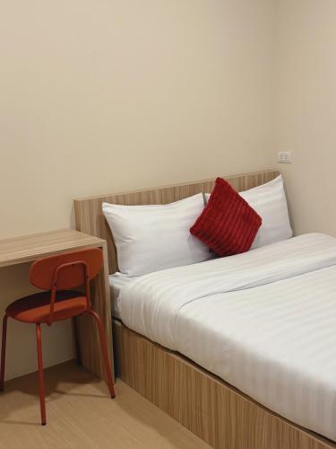 a bedroom with two beds and a chair next to a desk at Easy hostel-hotel, 1 min from train station in Hat Yai