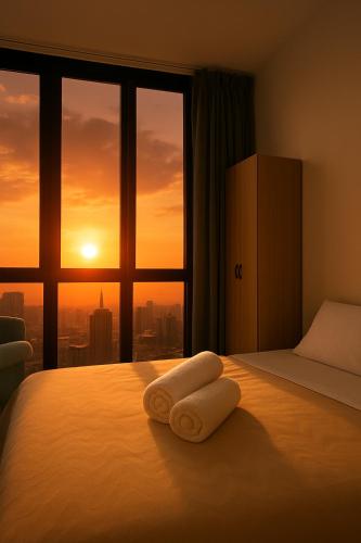 a bedroom with a bed with two towels on it at Premier Suites KLCC By Majestic Residence in Kuala Lumpur