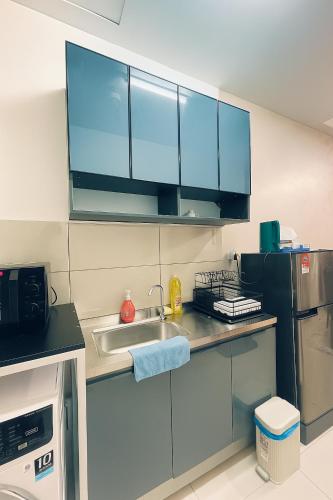 a kitchen with a sink and a refrigerator at Premier Suites KLCC By Majestic Residence in Kuala Lumpur