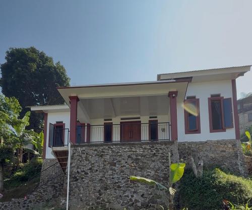 a small house with a stone wall at Mehar Villa in Gunungpicung