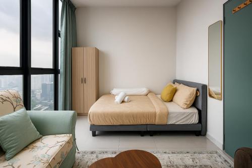 a small bedroom with a bed and a couch at Premier Suites KLCC By Majestic Residence in Kuala Lumpur