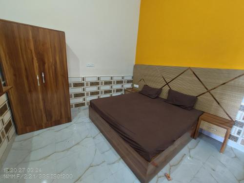 a bedroom with a bed and a wooden cabinet at Siddhi Vinayak paying guest house in Ayodhya