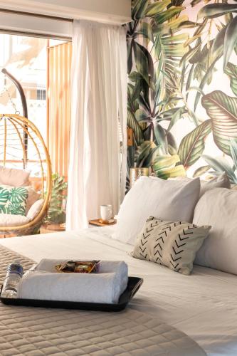 a bed with a tray on it with a tropical wallpaper at Waikiki Escape King Bed Pool Walk to Beach in Honolulu