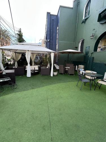 a patio with tables and umbrellas in a building at De Blasis Budget Rooms in Santiago