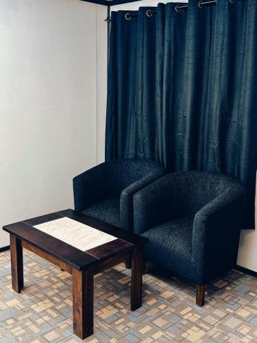 a room with a chair and a coffee table at Motel nidito de Amor in Curacautín