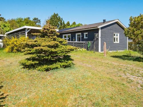 a house with a tree in front of a yard at 6 person holiday home in Hemmet in Hemmet