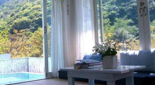a living room with a table and a large window at Brassiere Beach Hotel in Baanphakrimlay 