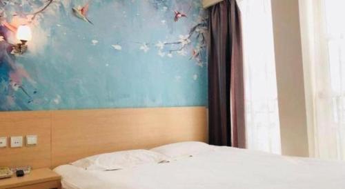 a bedroom with a bed and a painting on the wall at Super 8 Hotel Jinan Railway Station Square in Jinan