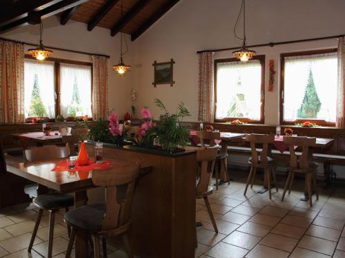 a restaurant with wooden tables and chairs and windows at Gasthof Rössle in Vogtsburg