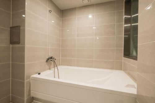 a white bath tub in a bathroom with a window at Signature Tourist Hotel in Seoul