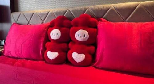 a group of red pillows with hearts on a bed at Wuhan Soluxe Hotel in Wuhan
