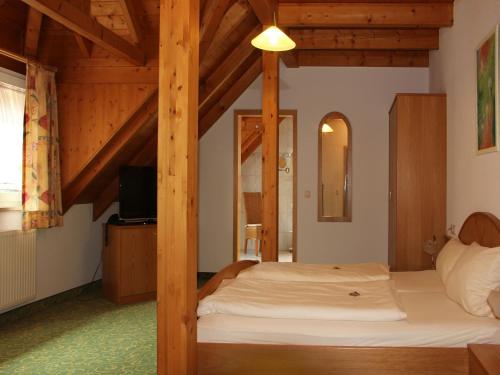 a bedroom with a bed in a room with wooden ceilings at Gasthof Rössle in Vogtsburg