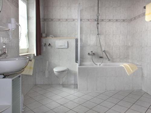 a bathroom with a tub and a toilet and a sink at Gasthof Rössle in Vogtsburg