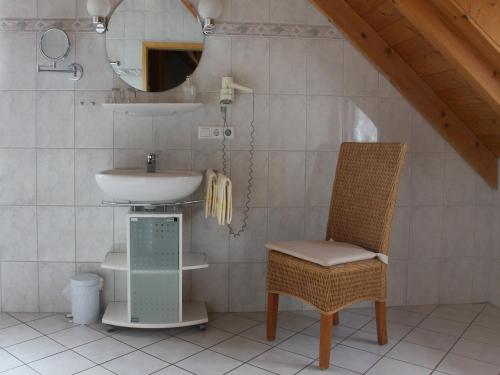 a bathroom with a sink and a chair and a mirror at Gasthof Rössle in Vogtsburg