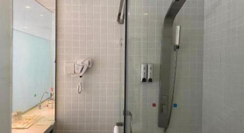a shower with a phone in a bathroom at 7Days Inn Tianjin Airport NO.1 Bridge Branch in Tianjin