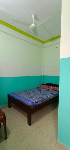 a bed in a room with a ceiling at Luiza Guest House in Baga