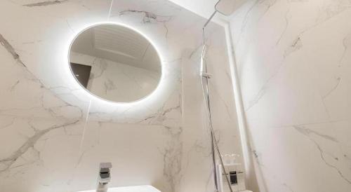 a white bathroom with a mirror and a sink at Plain Hotel in Chuncheon