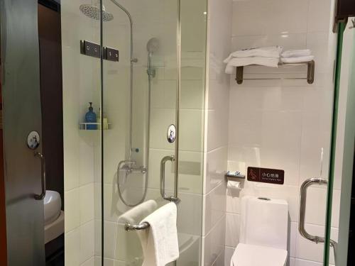 a bathroom with a glass shower and a toilet at 7Days Premium Yichang Railway Station East in Yichang