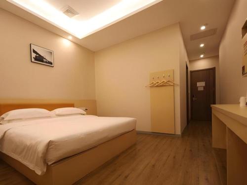 a bedroom with a large bed in a room at 7Days Premium Yichang Railway Station East in Yichang