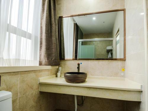 a bathroom with a sink with a mirror at 7Days Premium Yichang Railway Station East in Yichang