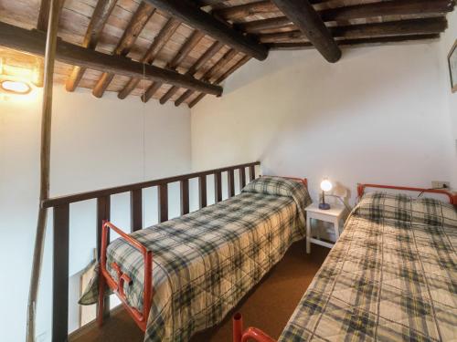 a bedroom with two beds and a table with a lamp at Rustic Chalet with Pool in San Marcello Pistoiese