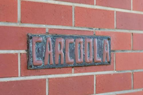 a metal sign on a brick wall at Ultima Escapes - Carcoola House - Barossa Fringe Retreat in Greenock