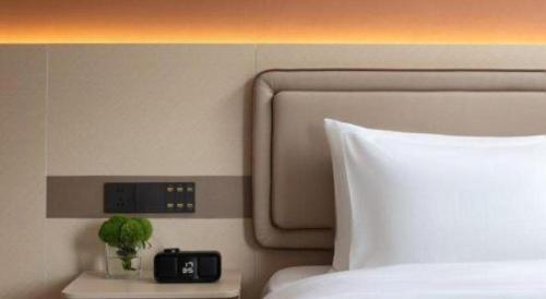 a headboard of a bed with a clock on the wall at Immersing Hotel Guilin Two Rivers and Four Lakes Dongxi Alley in Guilin