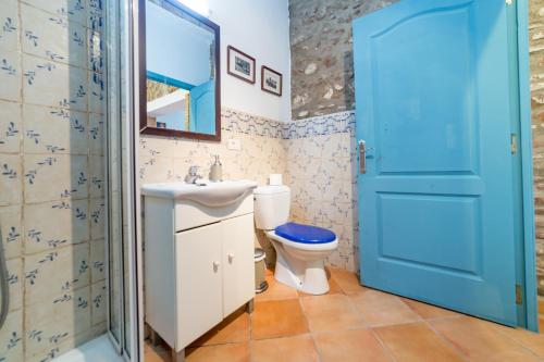 a bathroom with a toilet sink and a blue door at La Casa Azul in Alquerías del Niño Perdido