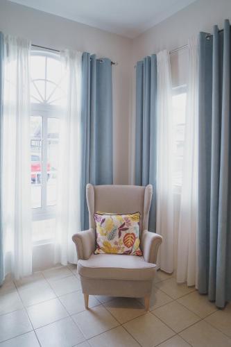 a chair with a pillow in a room with windows at Villa Izabella in Panglao Island in Dauis