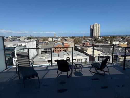 a balcony with chairs and a view of a city at Luxury Penthouse with Astonishing Bay and City Views in Melbourne