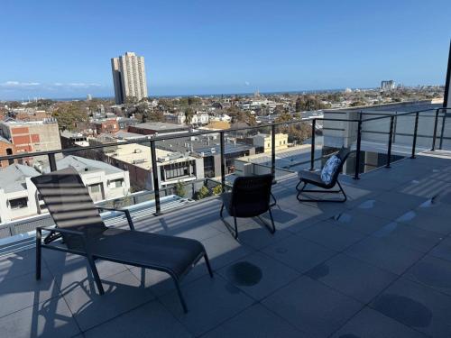 a balcony with chairs and a view of a city at Luxury Penthouse with Astonishing Bay and City Views in Melbourne