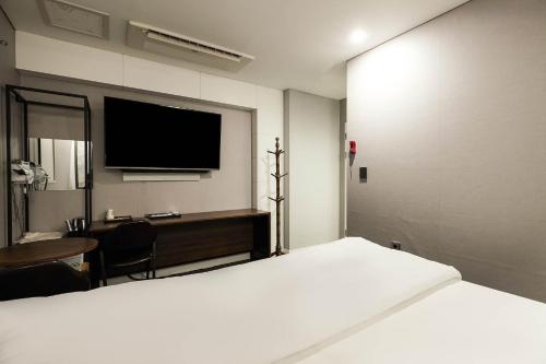 a bedroom with a bed and a desk and a tv at Signature Tourist Hotel in Seoul