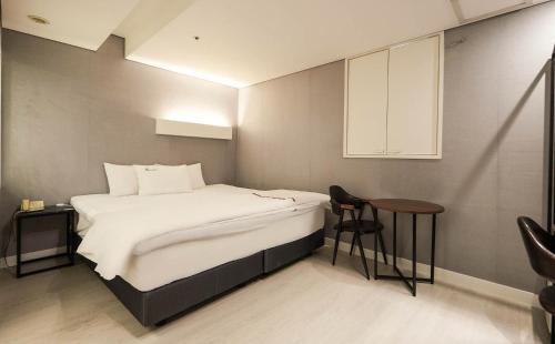 a small bedroom with a bed and a table at Signature Tourist Hotel in Seoul