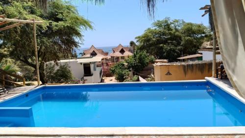 a swimming pool in a villa with blue water at Villa Naylamp loft en las pocitas in Máncora