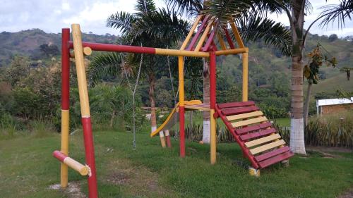 a playground with a slide and a swing at Alojamiento Rural San José in Cartago
