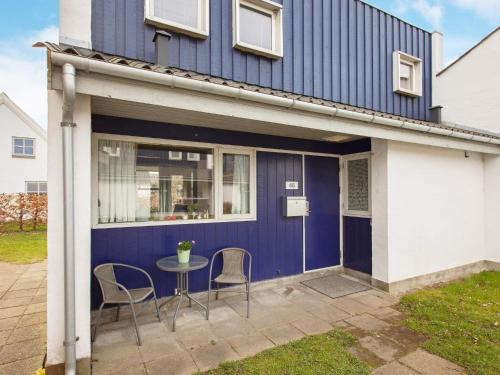 a house with a table and chairs on a patio at 4 person holiday home in Væggerløse in Marielyst