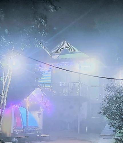 a foggy street with a building in the background at Green porticos villa munnar #MUNNAR in Anachal