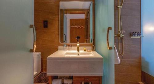 a bathroom with a sink and a mirror at James Joyce Coffetel Kunming Railway Station Huancheng Nan Road Metro Station in Kunming