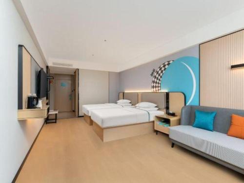 a hotel room with two beds and a couch at City Comfort Inn Shiyan Wudang Mountain in Danjiangkou