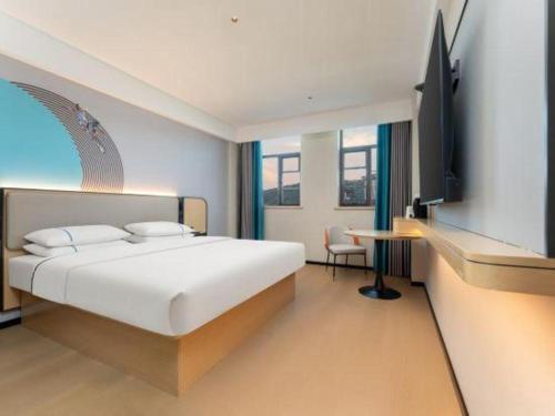 a bedroom with a bed and a tv and a desk at City Comfort Inn Shiyan Wudang Mountain in Danjiangkou