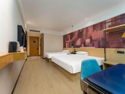 a hotel room with two beds and a blue chair at City Comfort Inn Shiyan Wudang Mountain in Danjiangkou