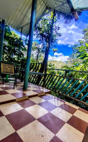 a porch with a bench and a view of the trees at Green porticos villa munnar #MUNNAR in Anachal